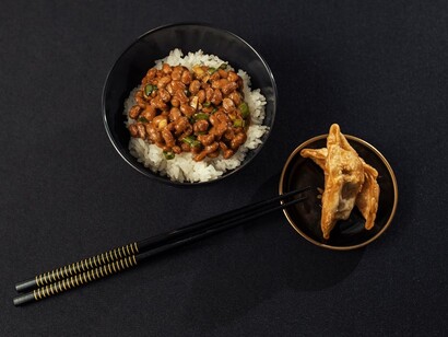 Nattō is a traditional Japanese dish made from whole soybeans fermented with Bacillus subtilis var. natto. It is commonly served for breakfast alongside rice, accompanied by karashi mustard, soy or tare sauce, and sometimes garnished with Japanese bunching onions