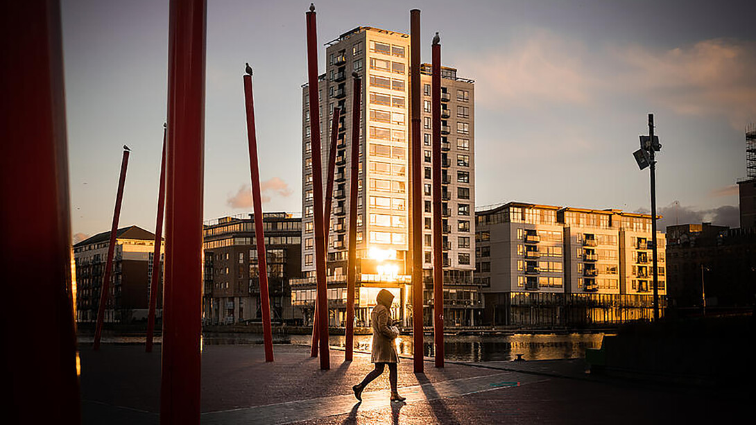 A woman walking through the streets of Dublin, Ireland, at sunset