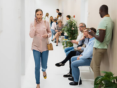 A packed hospital hallway filled with patients waiting in chairs or standing along the walls