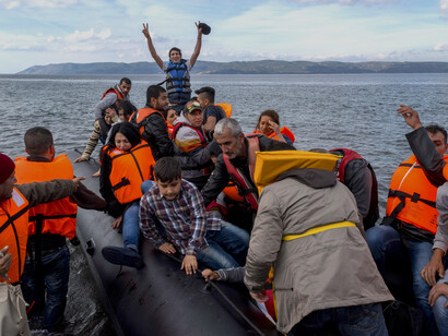 The arrival of a migrant boat on Lesbos, Greece reflects the human face of the migration crisis and the complexities of border control and international migration