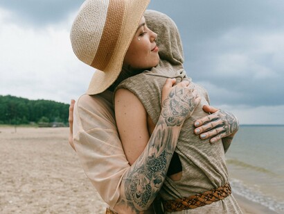 Two people offering mutual comfort by the water, symbolising the role of secure relationships in emotional regulation