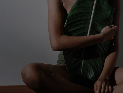 A woman delicately cradles a colossal leaf in her hand