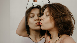 Mulher beija seu reflexo no espelho