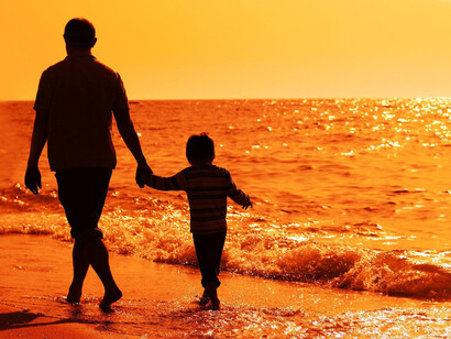 Desencuentro. Padre e hijo pasean por la playa