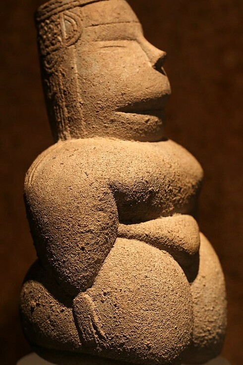 Deidad femenina con tocado de pandereta, en calcarenita, de su cuccuru s'arriu, cabras, Cerdeña, Italia