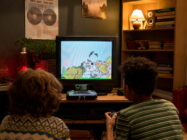 Teenagers gathered around an old television, playing nostalgic video games and reliving the charm of a bygone era