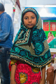 In a factory far from the consumer's eye, a girl works tirelessly for wages that barely cover the cost of living, embodying the human cost of fast fashion