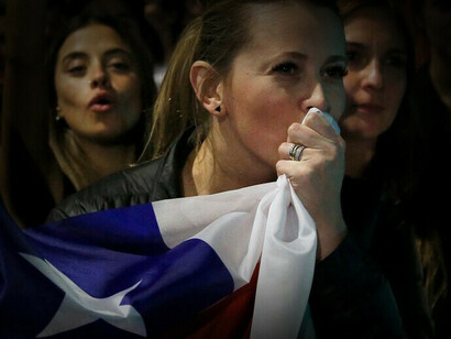 A woman kisses the Chilean flag as a sign of victory