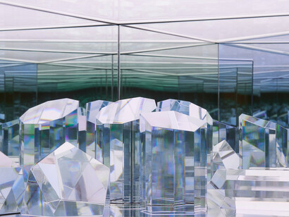 Josiah Mcelheny, Prismatic Refractive Geometry I (detail), 2023. Hand-formed, cut, and polished solid geometric glass shapes; low-iron mirror and two-way mirror; electric light; cedar frame, 23 x 86 1/2 x 20 in. Courtesy of James Cohan Gallery
