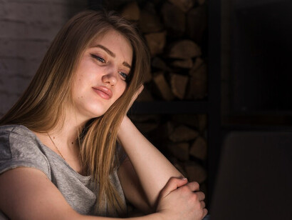 A woman working remotely on her laptop, appearing stressed and overwhelmed—capturing the blurred boundaries between work and personal life