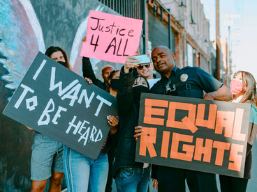 A crowd of protesters with equality signs and taking pictures, symbolising the role of digital tools in modern movements