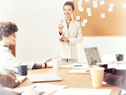 Another female member of a digital marketing group stands in front to share her ideas with the other members