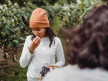 A woman chewing on blueberries as part of her fitness diet