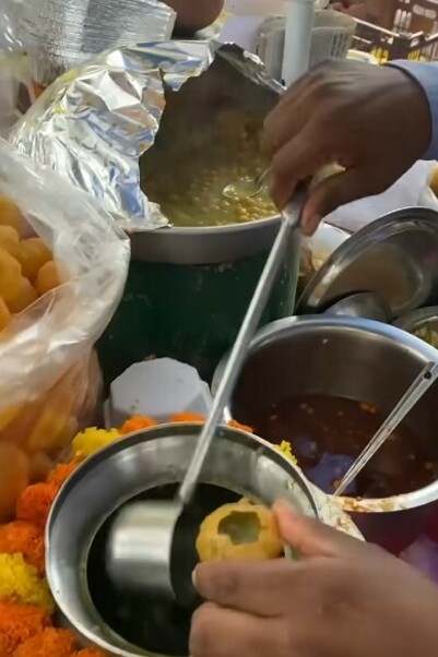 Traditional gol gappa preparation by a vendor on the lively streets of Mumbai, India