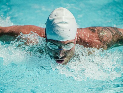 A man swimming in a pool, a gentle yet effective method of rehabilitation that promotes strength and flexibility while minimizing strain on the body