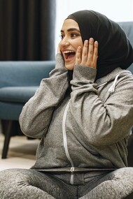 A woman wearing sporting clothes having to decide between two plates of diverse foods
