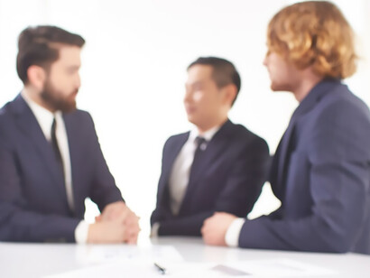 Three individuals engage in discussions around a table, exchanging smiles and fostering an atmosphere of collaboration in the field of lobbying