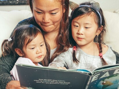 Mãe lendo com filhas