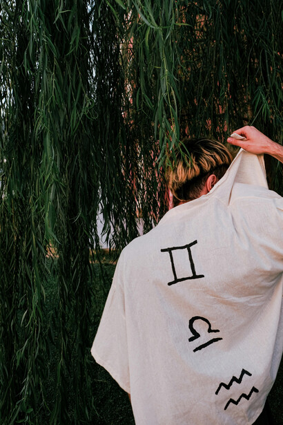 Una persona mostrando los signos zodiacales que lleva en la espalda