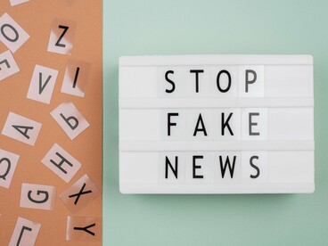 A backlit sign reading “Stop fake news,” symbolising the need for factual integrity in an era of viral content