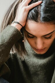 Une femme tenant sa tête dans la frustration, la douleur et la colère, probablement coincée dans une difficulté