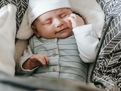 A baby dreaming a happy dream in the stroller