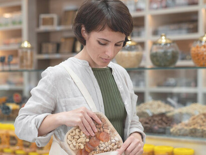 A woman browses through various goodies at a local producer, emphasizing nutritional preservation and innovative food packaging