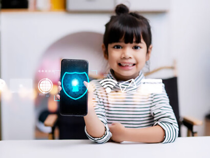 A little girl interacting with her smartphone at home, featuring an internet-blocking app icon, highlighting the importance of child safety online, AI regulation, and technology-driven child protection