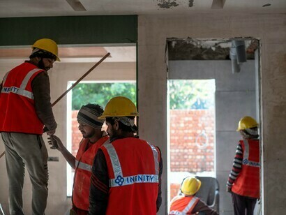 Des ouvriers du secteur de la construction collaborant sur un chantier, illustrant le rôle essentiel du travail décent dans la prévention de la pauvreté
