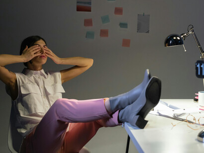 Professional woman working late in the office, showing visible signs of stress