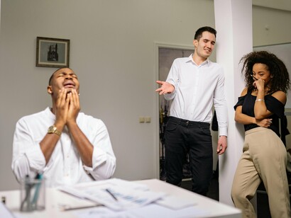 Homem sofre com a fofoca no ambiente de trabalho. A fofoca no ambiente de trabalho pode ser definida como a transmissão não autorizada de informações ou comentários sobre outras pessoas, geralmente de maneira negativa ou prejudicial