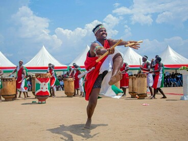 Un danseur en costume de cérémonie burundais exécutant une danse traditionnelle, symbolisant les racines culturelles qui ancrent le sentiment d'appartenance à la communauté