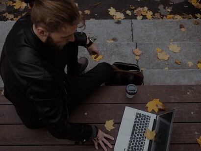 Homem trabalha em seu laptop no outono