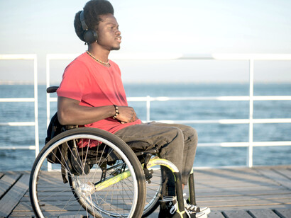 A man with Afro hair in a wheelchair, symbolizing personal transformation, self-discovery, cognitive growth, and the healing journey