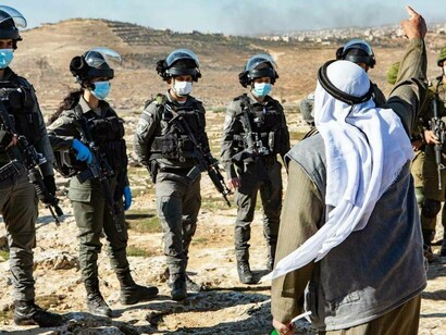 Israeli soldiers outnumbering a Palestinian person in his homestead