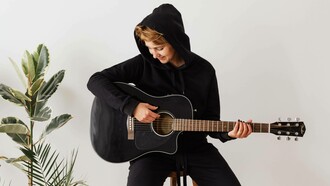 Person playing the acoustic guitar