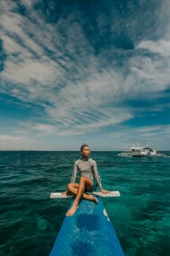 A woman wearing a rash guard in the sea in the Philippines, enjoying a peaceful travel moment
