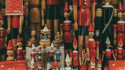 Una serie di fantocci di legno di pinocchio in una vetrina