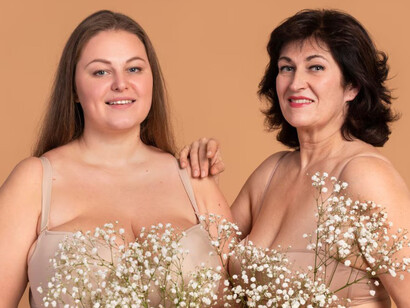 Smiling women of different ages posing with flowers in a medium shot, representing the premenopause stage