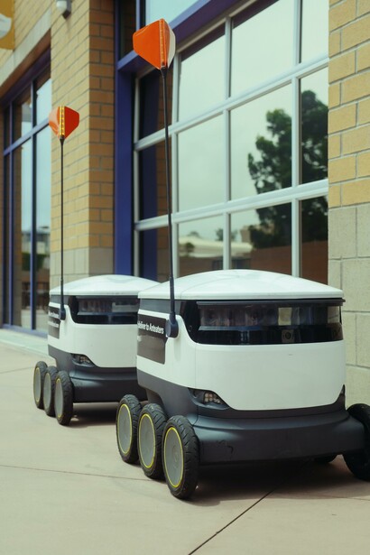 Two delivery robots on a pavement 