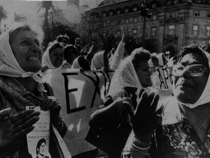 The Madres de Plaza de Mayo stand resilient in the Plaza de Mayo, the public square located in front of the Casa Rosada presidential palace, Buenos Aires, Argentina, holding signs and memories of their disappeared children as a symbol of hope and justice
