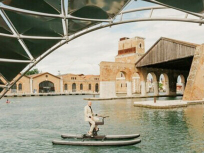 Sólo él, el agua y el pedaleo. Así fue la entrada de Norman Foster a la Bienal de Venecia, en hidropedal. Fotografia Cortesia Bienal. Norman Foster en hidropedal, Venecia, Italia