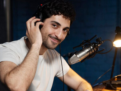 A man in a recording studio, using a microphone and headphones, working on dubbing and subtitle synchronization