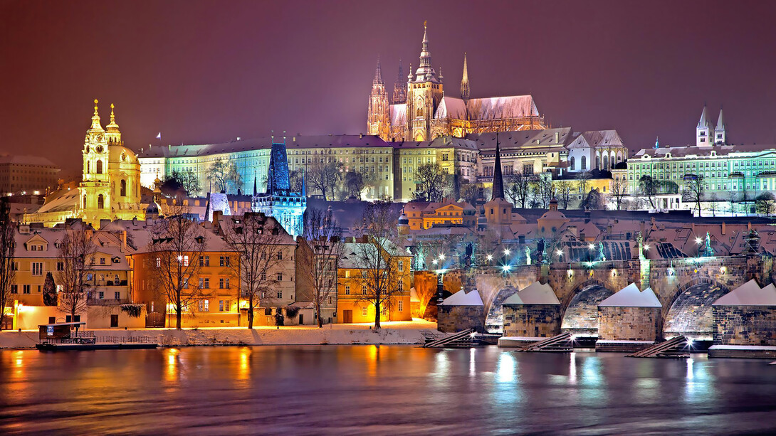 The Prague Castle District beautifully illuminates at night, casting a magical glow over the city