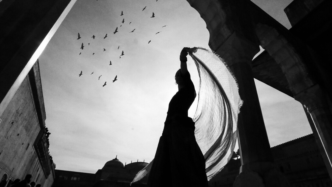 A woman dancing as birds fly in the background, reflecting the self-expression and freedom the art form brings
