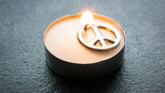 Eine Kerze und das Friedenszeichen von Gerhard Holtom