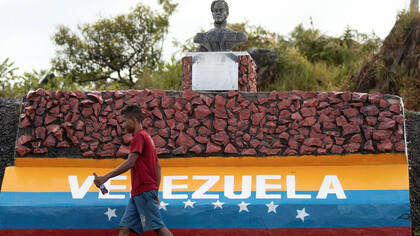 Ciudadano camina frente a una escultura conmemorativa de Simón Bolívar, Venezuela
