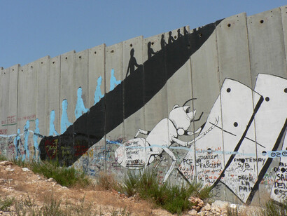 Una pintada invita a saltar el muro entre Israel y Palestina