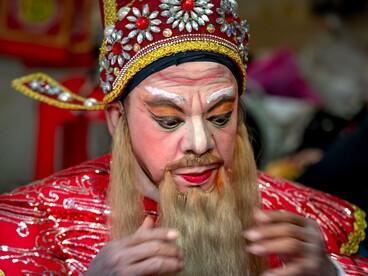 An opera performer carefully adjusting his costume before the performance, representing the fragile boundary between cherished dreams and everyday reality