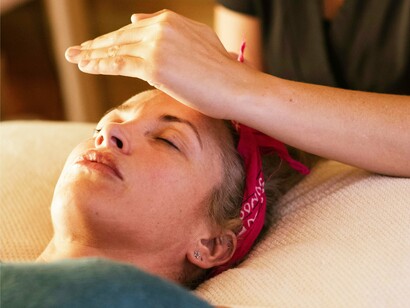 Mulher recebe Reiki. As palavras em japonês podem ser escritas por ideogramas e exprimem uma ideia. Os ideogramas que representam a palavra Reiki podem significar a ideia de algo que vem do Cosmo e, no encontro com a Terra, produz o milagre da vida; ou a comunhão de uma energia superior com uma energia terrena; ou chuva maravilhosa que dá vida, uma chuva maravilhosa de energia vital